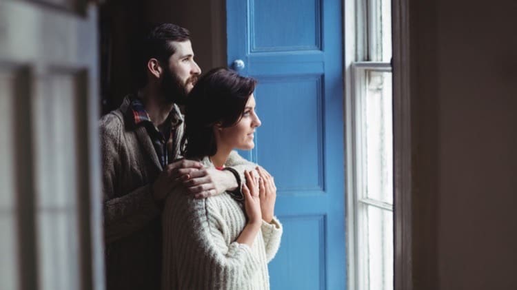 man embracing woman while looking through window cropped 7